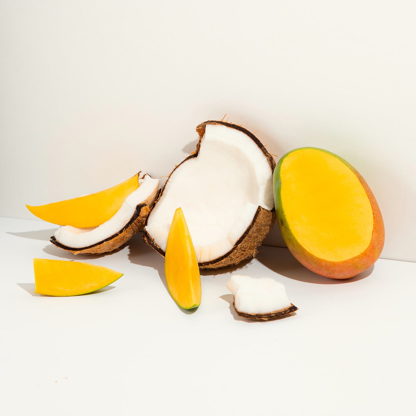 Stylized photograph of cut coconut and mangos