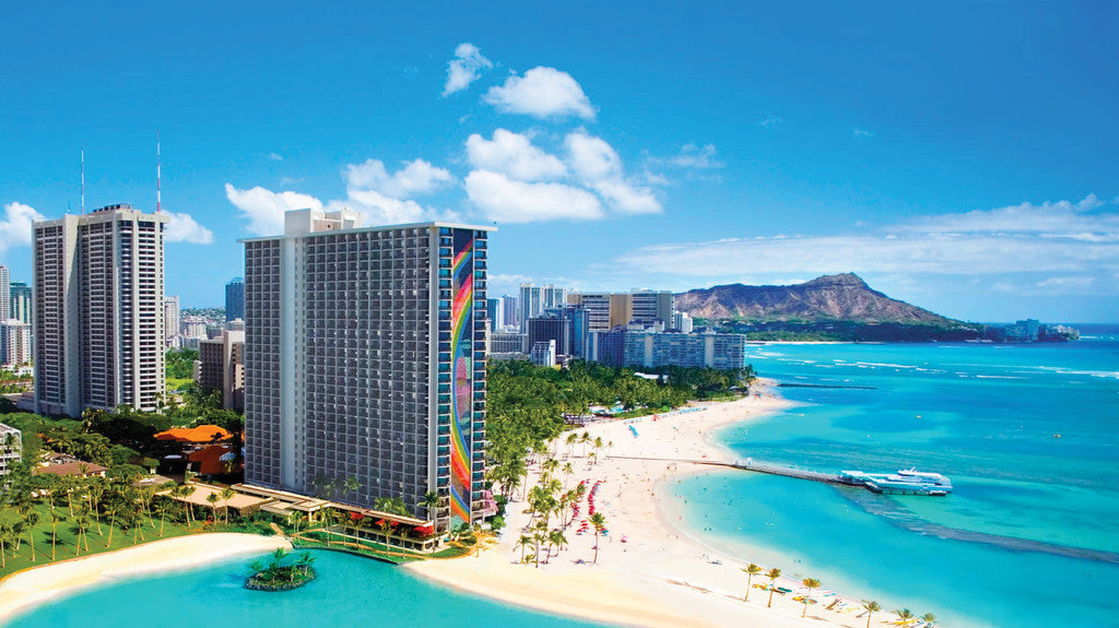 A panoramic view of the Hilton Hawaiian Village revealing the vibrant rainbow mural with the ocean.